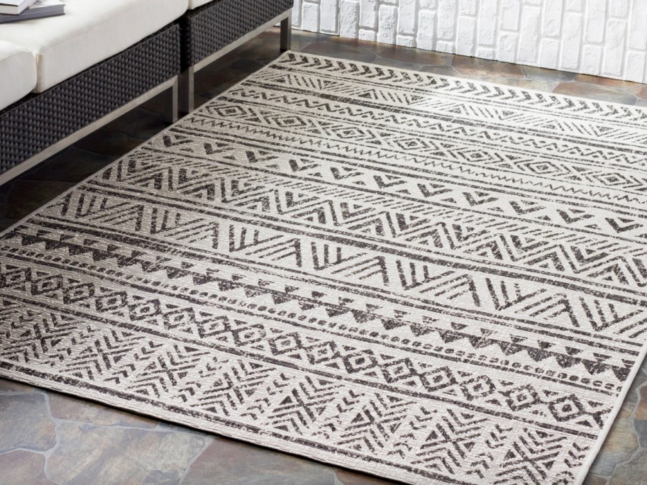 black and white geomatric rug ouside under couch
