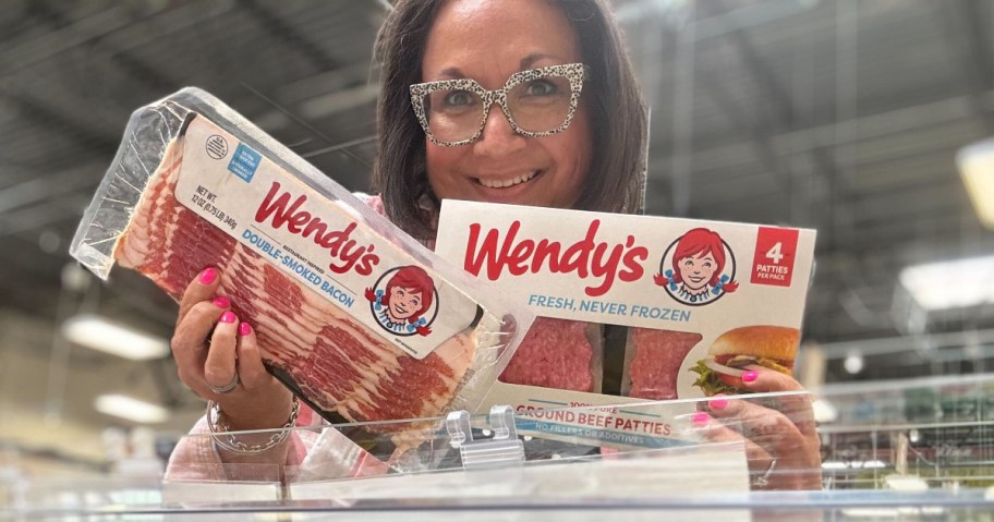 woman holding up Wendys bacon and burger patties in a grocery store