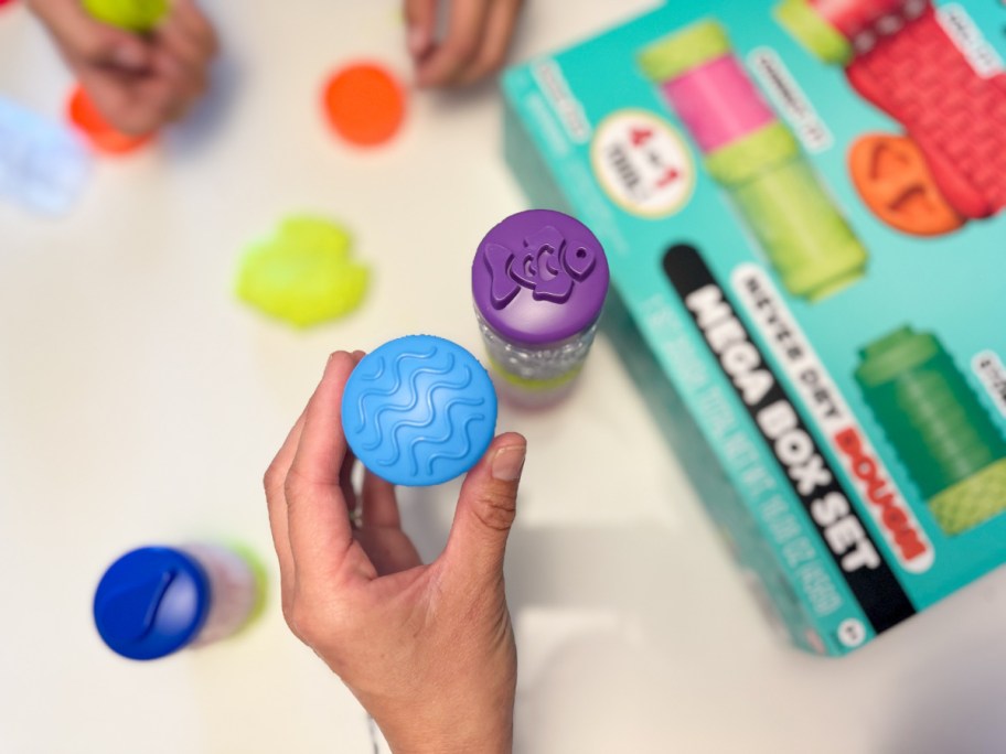 hand holding pieces from a play dough kit