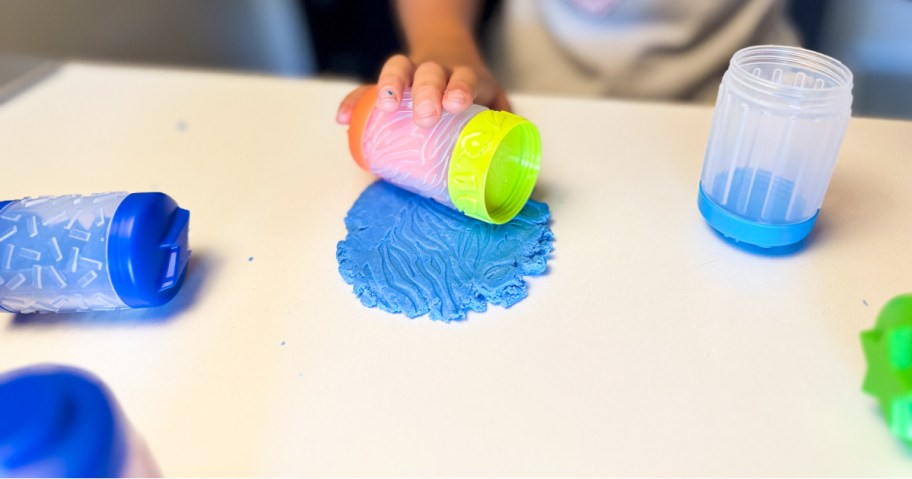 hand rolling a tool on top of play dough