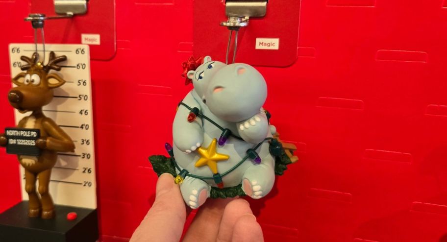 hand holding hippo wrapped in christmas lights ornament 