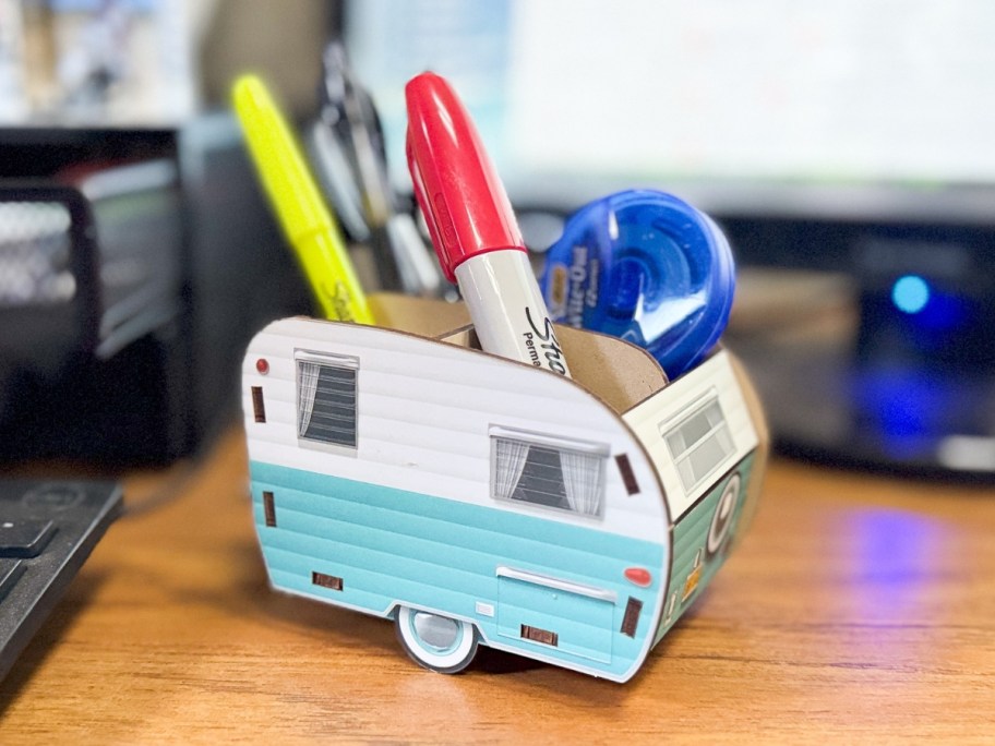 a vintage camper pencil holder with pens and pencils on a desk