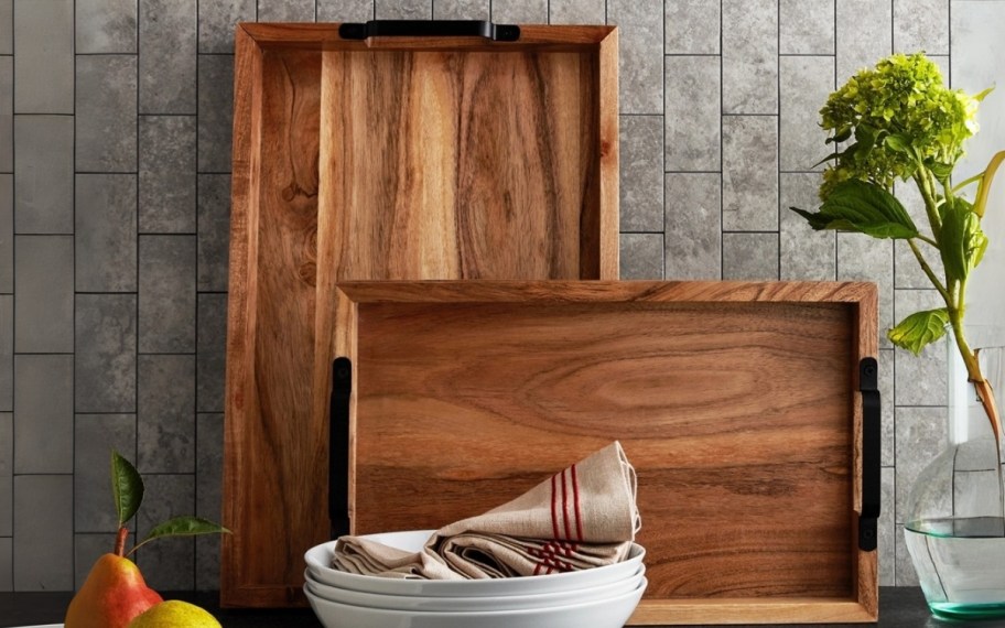 two wooden serving trays leaned against a backsplash