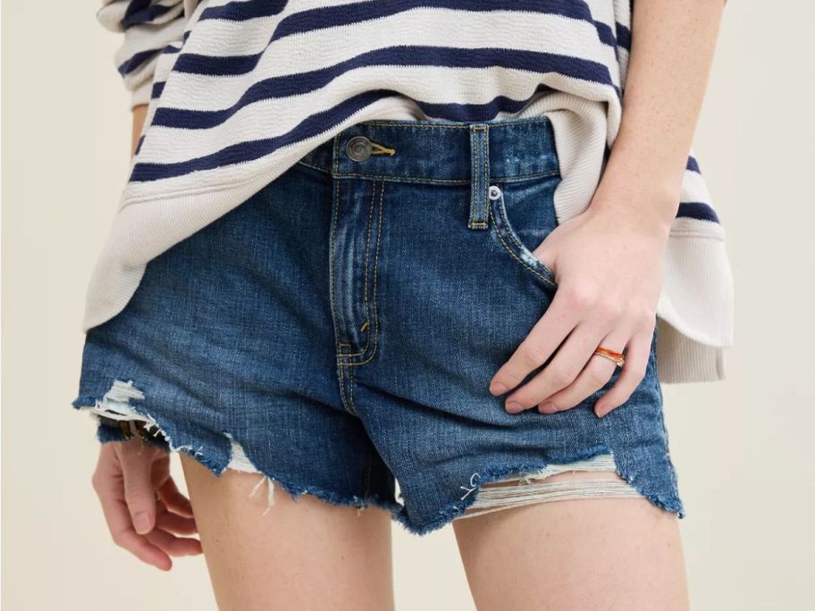A woman wearing a cut off pair of denim jeans