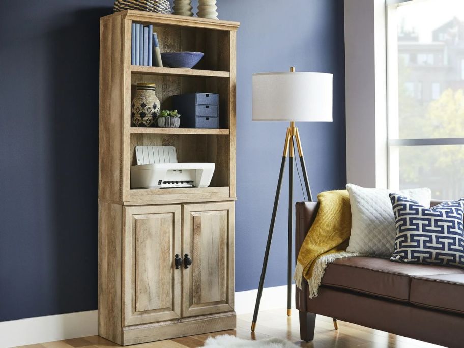 A Better Homes & Gardens Crossmill 5 Shelf Bookcase with a printer and other office items on it