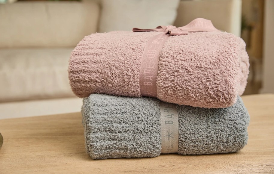 Pink and gray barefoot dreams blanket on table