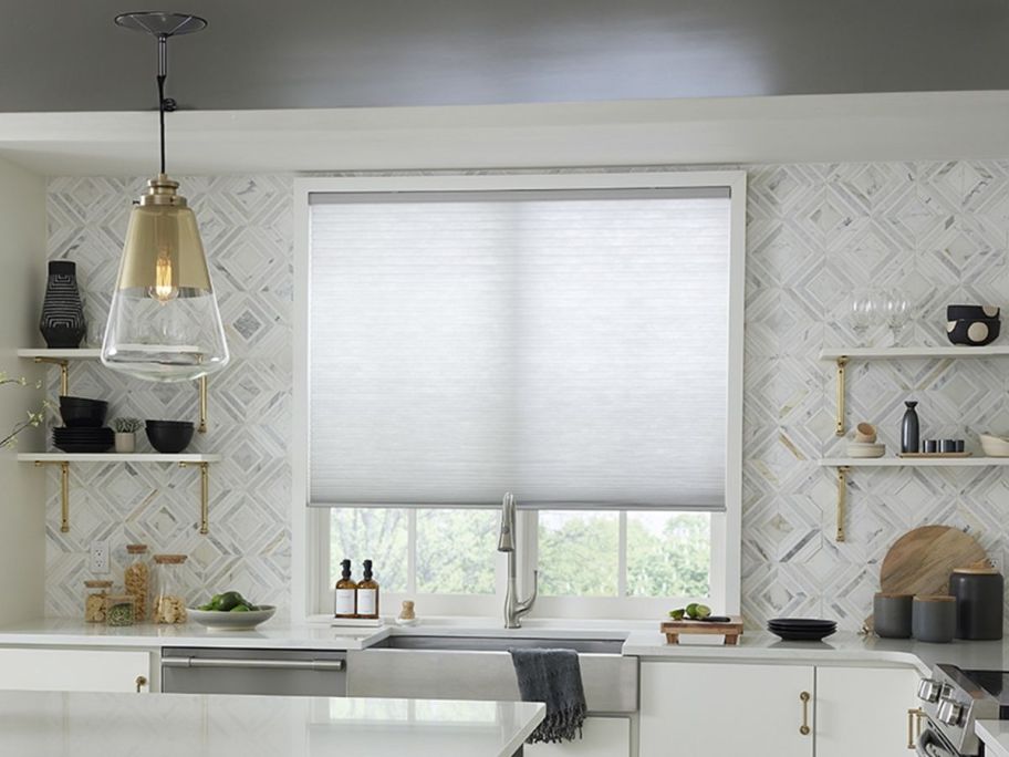 cellular shades in front of a kitchen window 