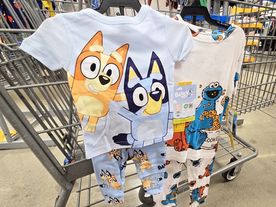 bluey and sesame street pajama sets hanging from cart