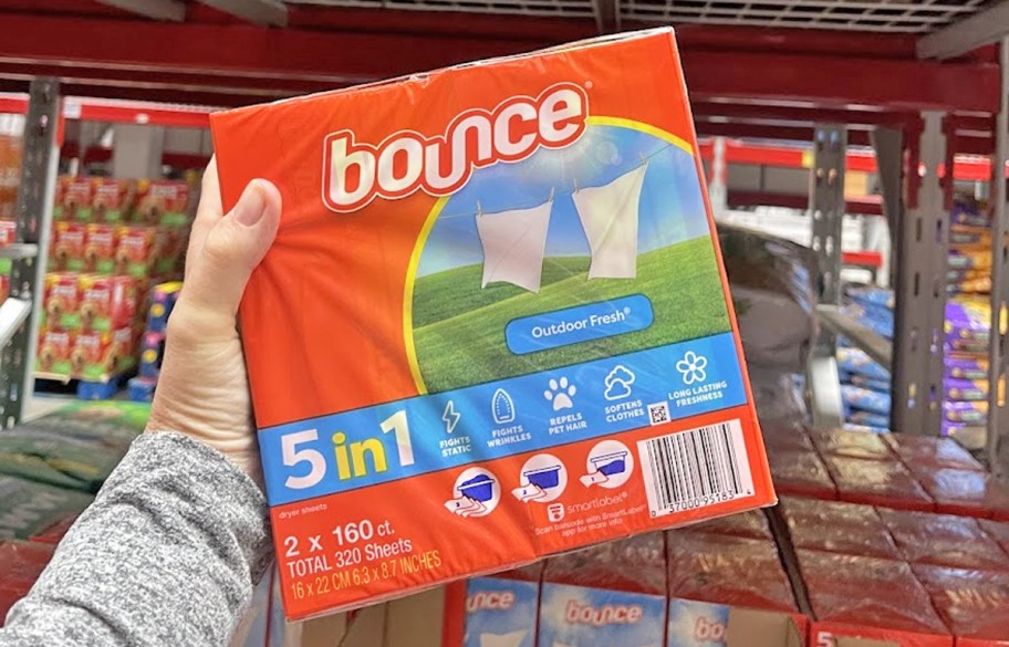 hand holding up a large orange box of Bounce Fabric Softener Dryer Sheets