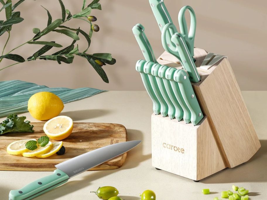 A block of Green carote knives with one large chef knife taken out and set next to it
