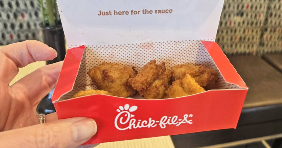 hand holding up a box of Chick-fil-A nuggets
