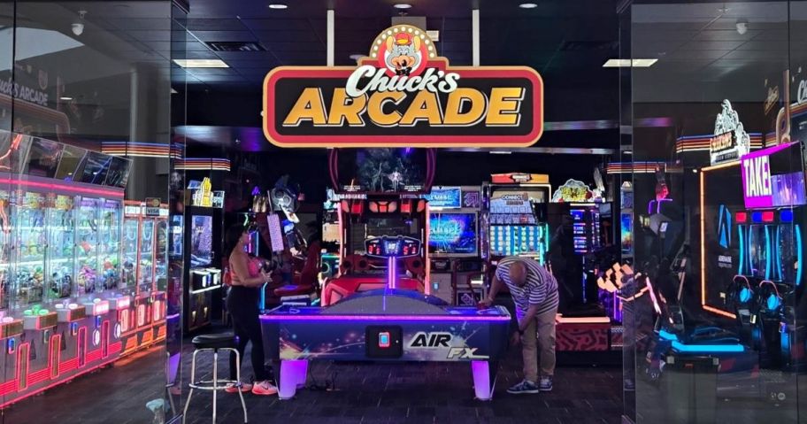 A man playing air hockey in an arcade