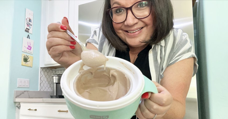 woman holding up chocolate ice cream in a mini ice cream maker bowl