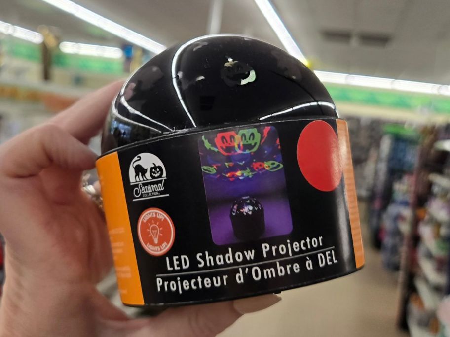 Hand holding a Halloween LED Shadow Projector at Dollar Tree