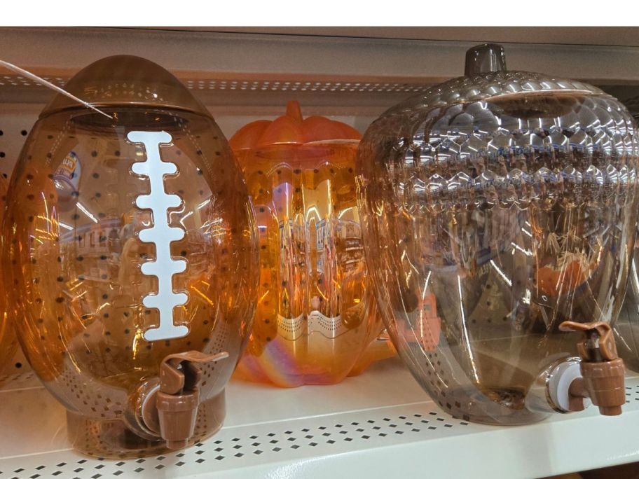 A shelf of Football, Pumpkin and Acorn figural drink dispenders at Dollar Tree