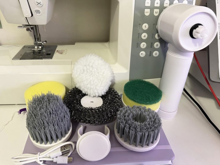 variety of brush heads next to a white spin scrubber tool