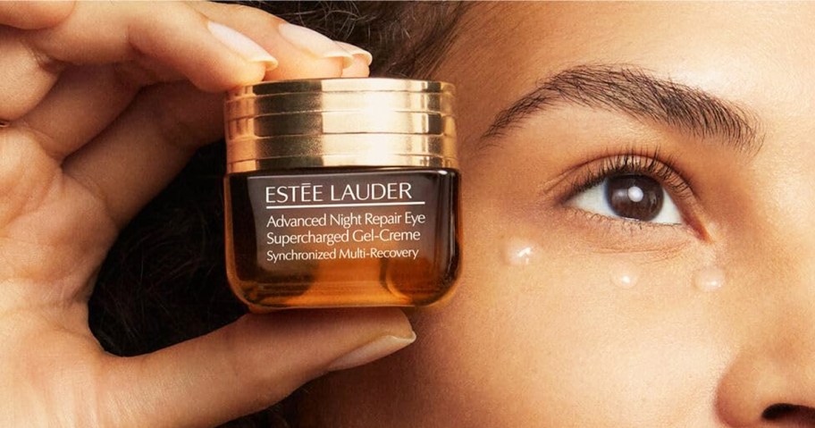 woman holding brown jar of Estée Lauder Advanced Night Repair Eye Supercharged Gel-Cream near her eye