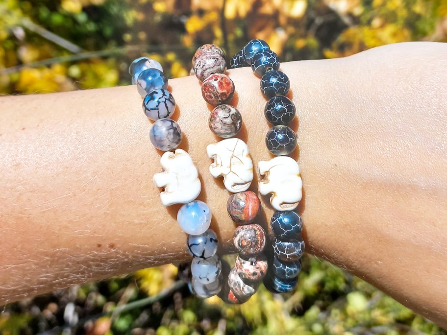person wearing 3 elephant bracelets