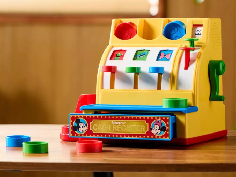 A Fisher Price Mickey Mouse Cash Register on a table