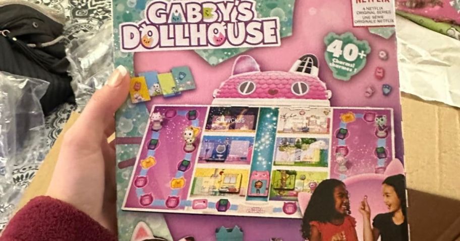 Hand holding a Gabby's Dollhouse Board Game