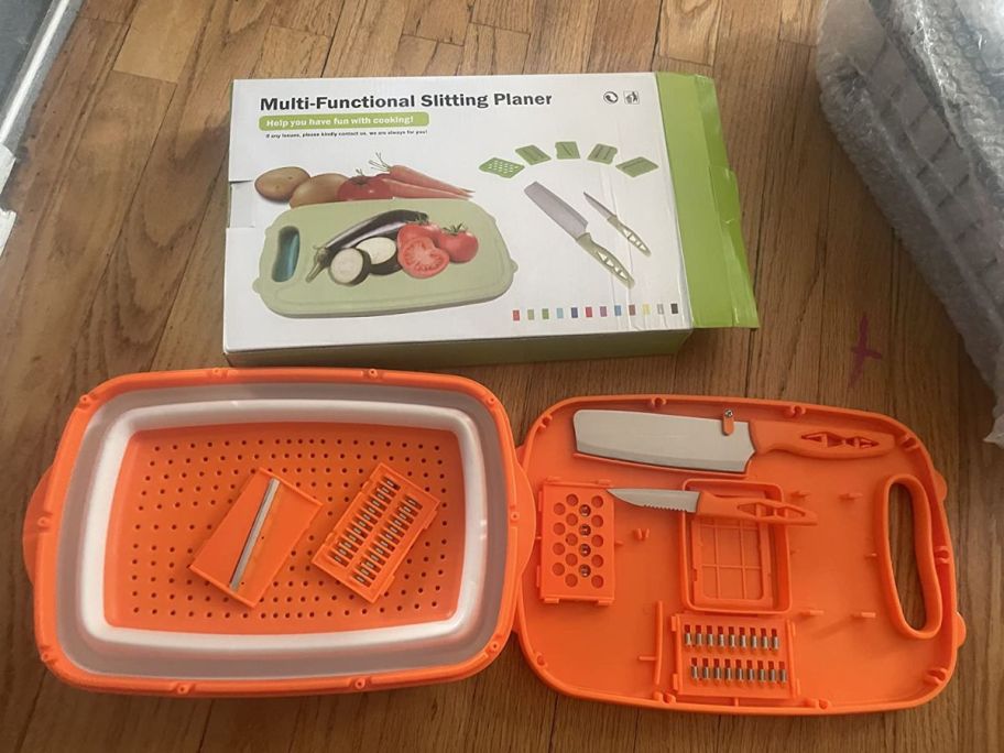 An orange cutting board with various kitchen tools on a counter
