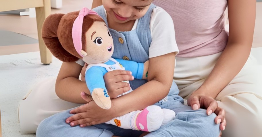 little girl with a Ms. Rachel plush doll