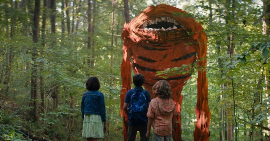3 kids looking at a strange creature in the woods