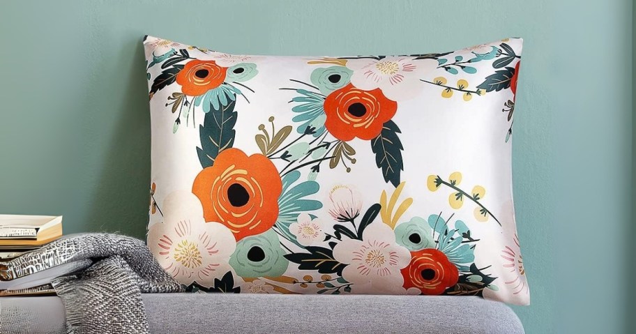 a floral satin pillowcase on a bench