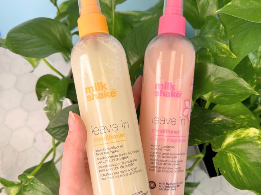 hand holding 2 bottles of Milk Shake Leave-In Conditioner Spray Detangler