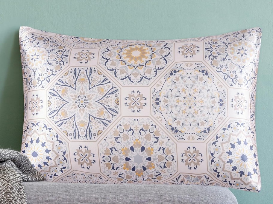 a medallion print satin suitcase on a bench