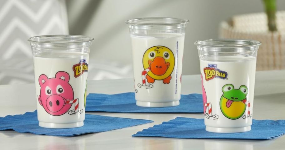 3 Hefty Zoo Pals Cups filled with milk set on blue napkins