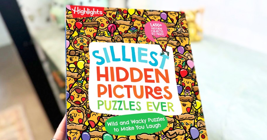 hand holding up Highlights Silliest Hidden Pictures Puzzles Ever Book