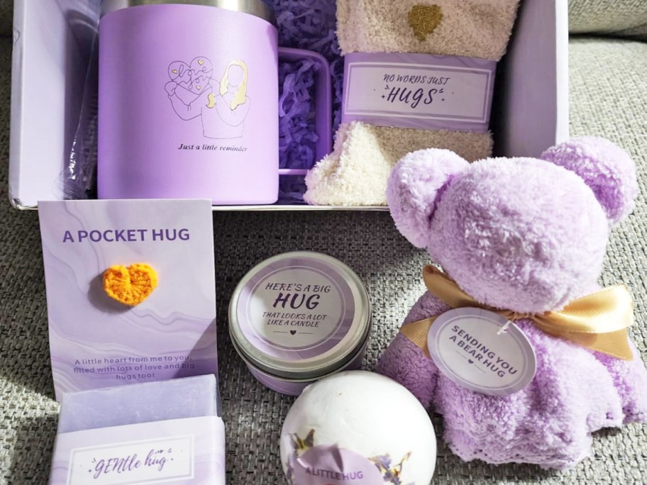 various purple self care gifts in front of a box