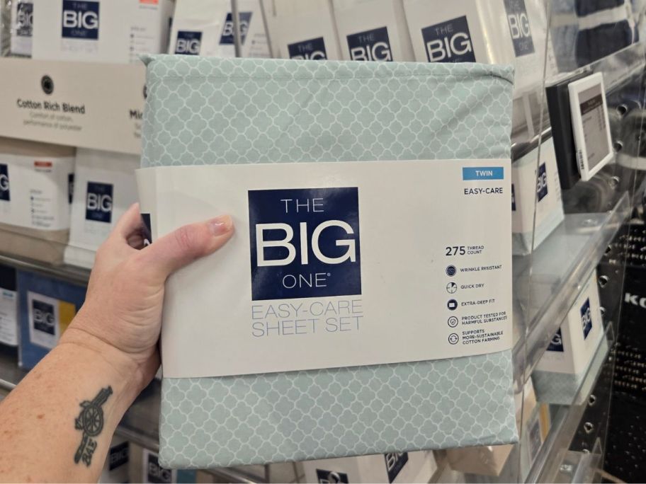 Hand holding up a pack of The Big One Easy Care Sheets