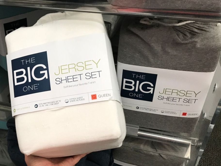 Hand holding a pack of The Big One Jersey Sheets 