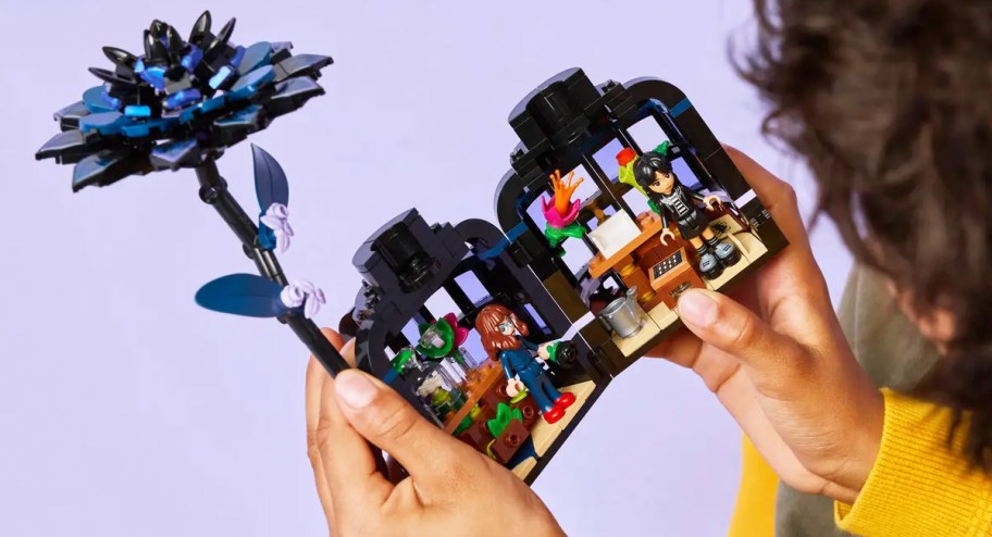 child holding the LEGO Wednesday Black Dahlia Flower Set