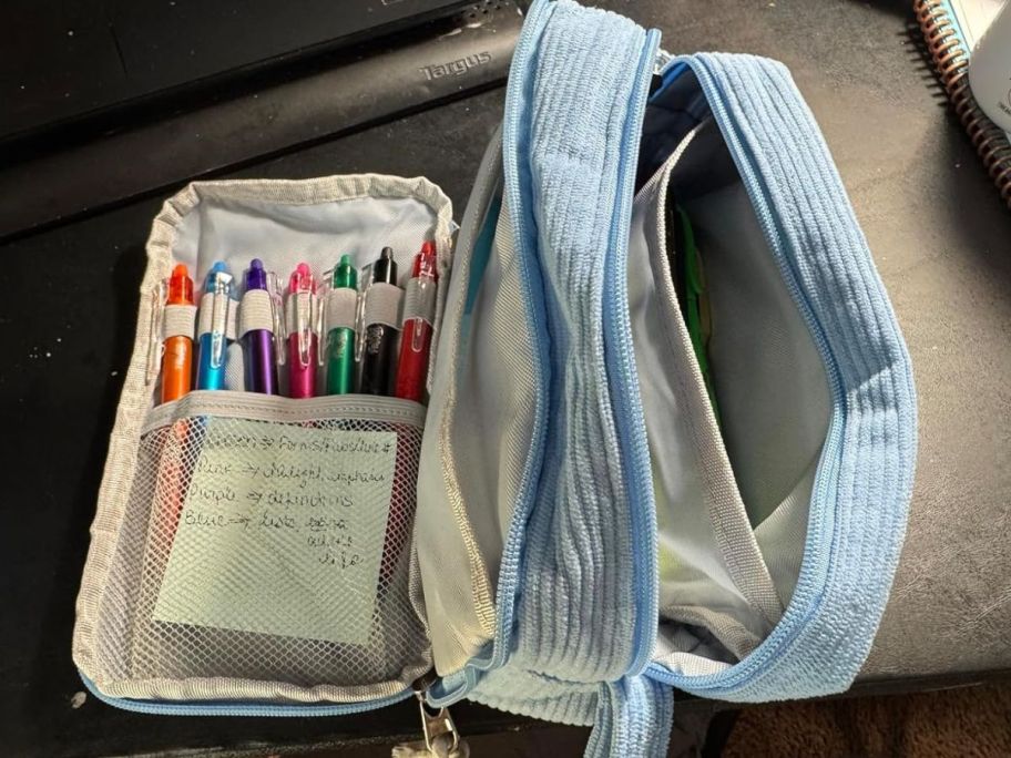 corduroy blue bag opened up with pens showing