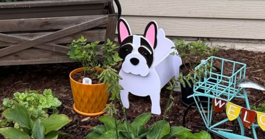A dog-shaped planter in a garden
