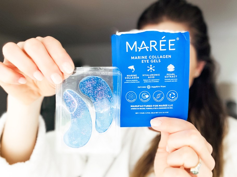 woman holding up a set of blue sparkly under eye matches