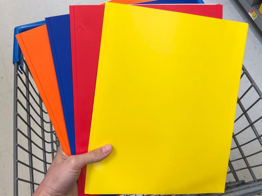 Hand holding paper folders in assorted colors