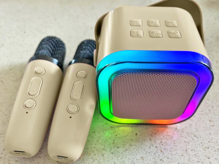 white mini karaoke machine with rainbow led lights and 2 mini microphones