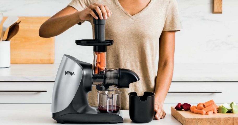 Woman using a Ninja Juicer to make vegetable juice