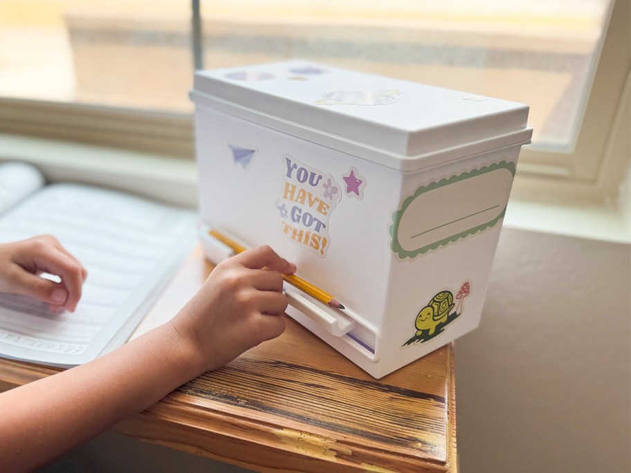 Pen+Gear DIY Pencil Dispenser w: 5 Sticker Sheets being used by a kid at a desk near a window