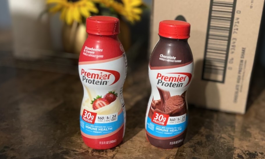 a strawberries and cream and chocolate protein shakes on a counter