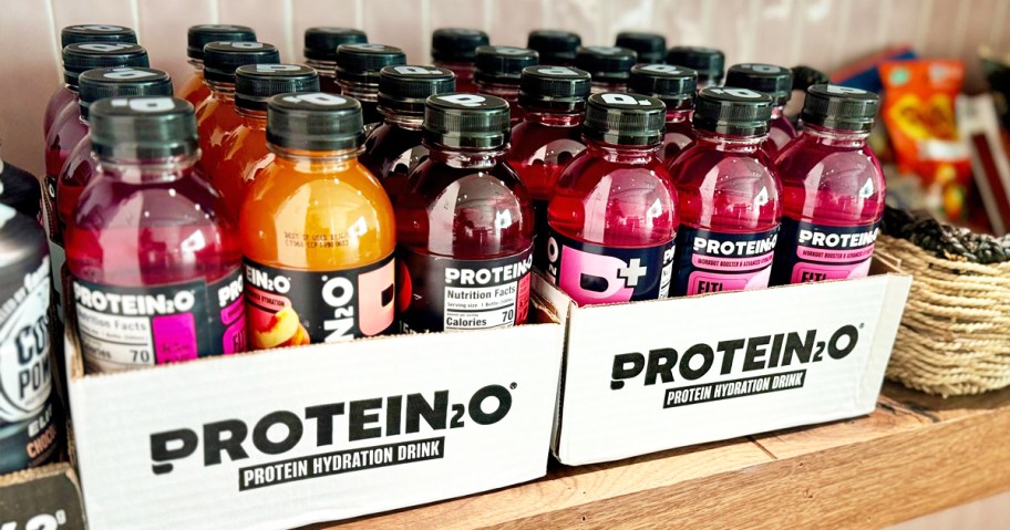 cases of Protein2o bottles in various flavors on counter 
