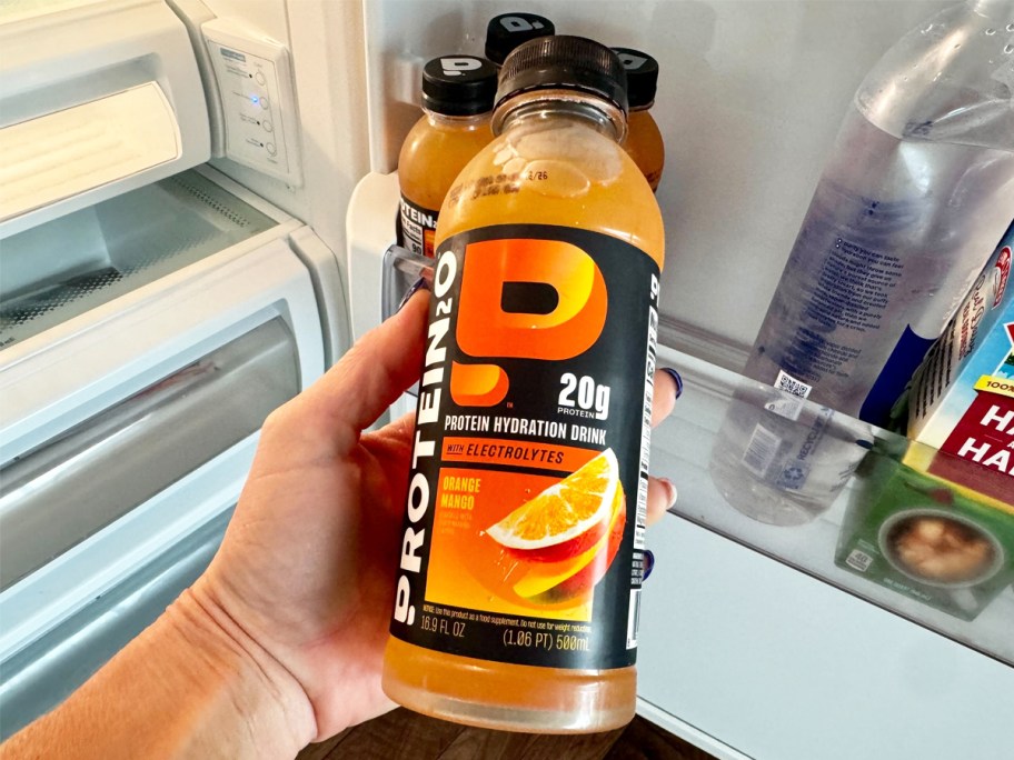 hand grabbing an orange Protein2o bottle from fridge