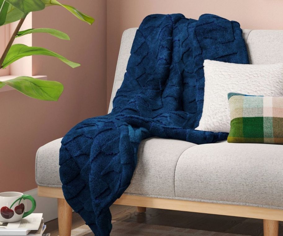 a blue jaquard throw blanket draped across a sofa
