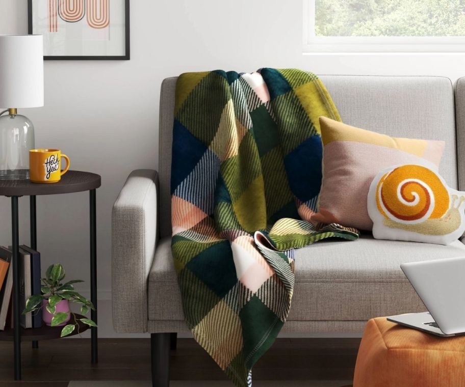 a plaid throw blanket draped across a sofa