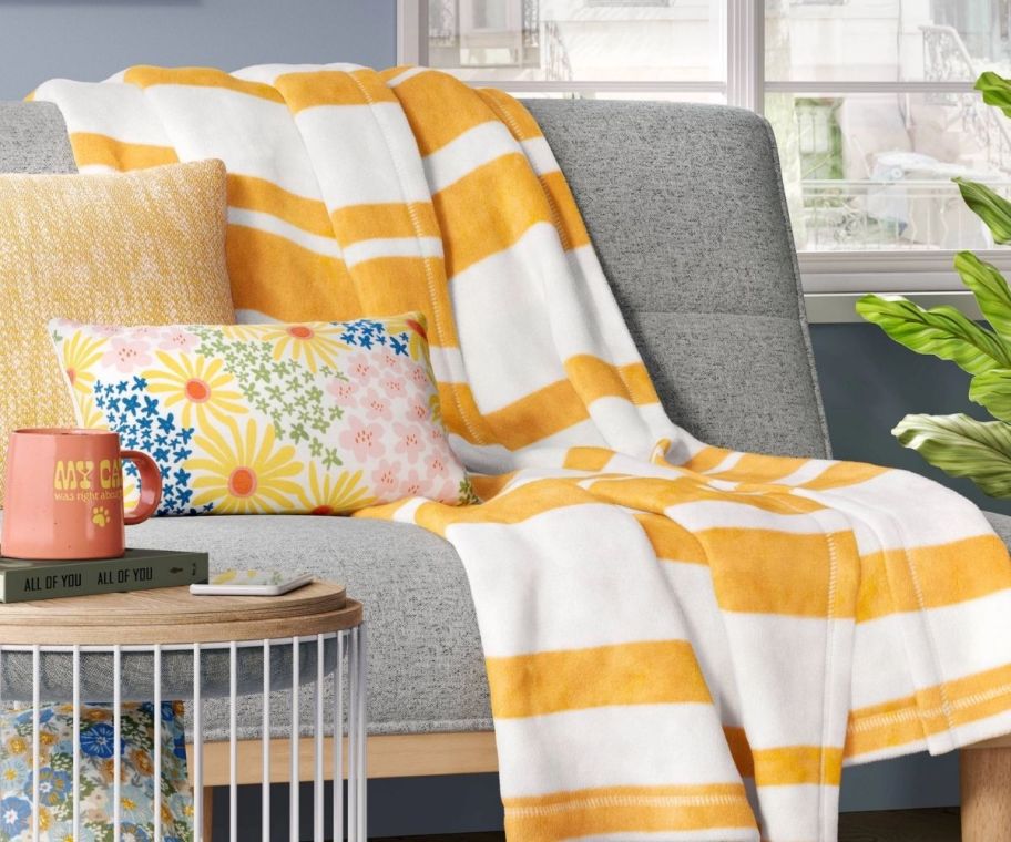 a yellow and white striped throw blanket draped across a sofa