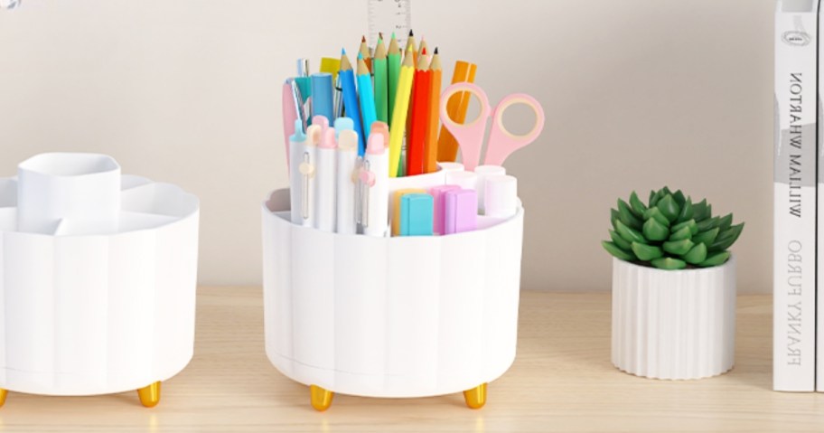 rotating desk caddy organizer on table filled with markers, pencils, scissors, and sticky notes
